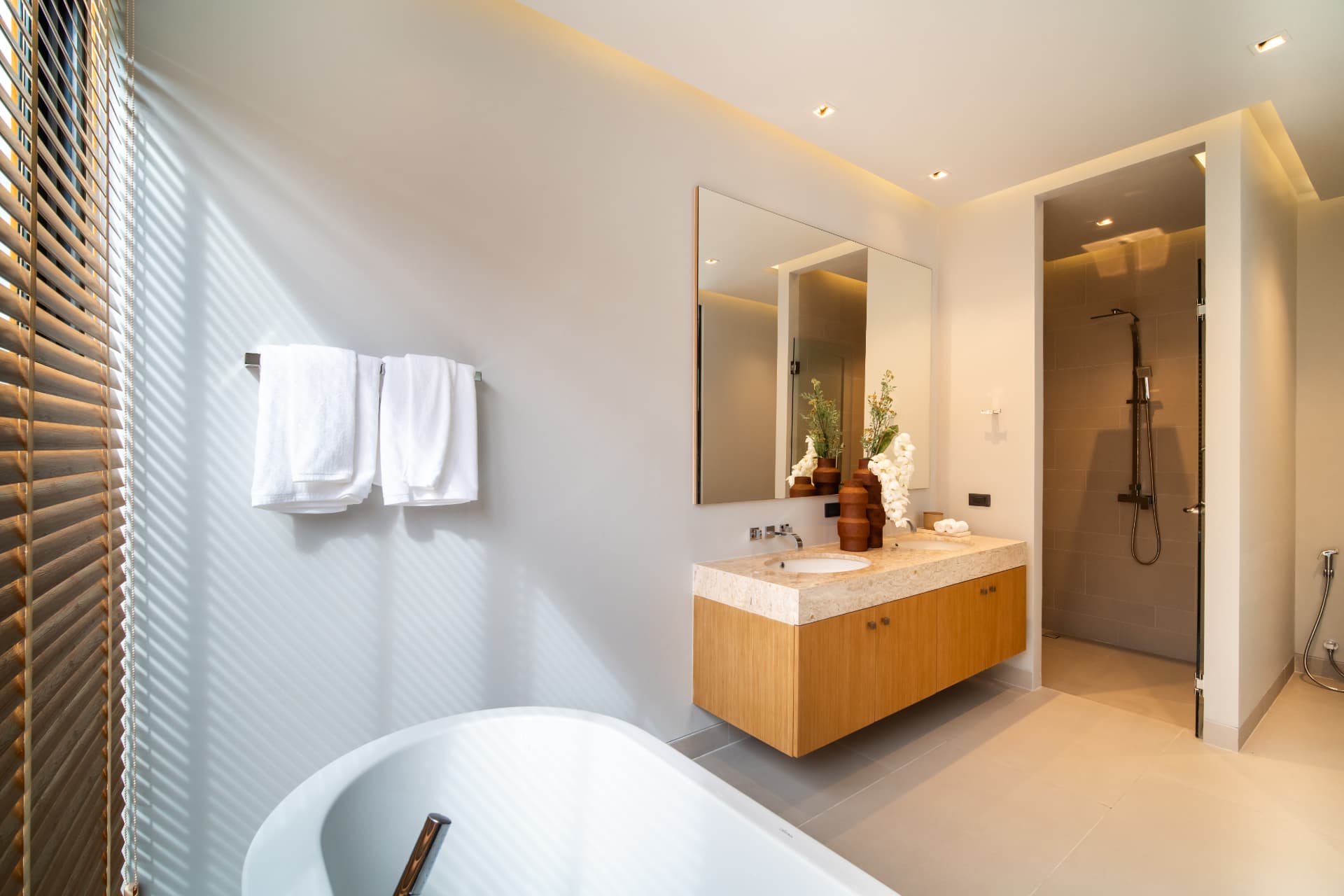 Botanica Four Seasons — floating oak vanity with marble counter and frameless mirrors