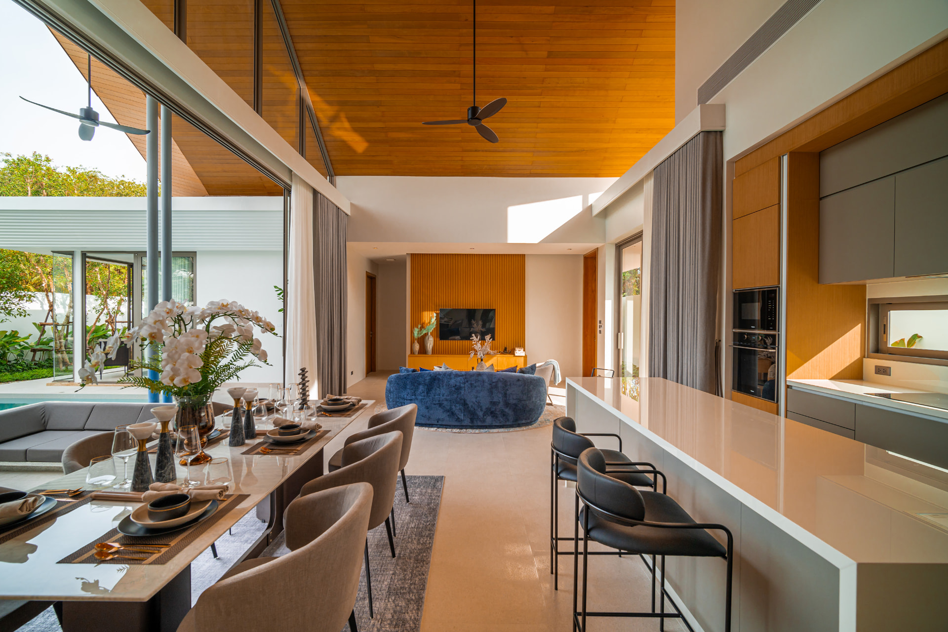 Botanica Louvre — dining table and kitchen island under a timber ceiling