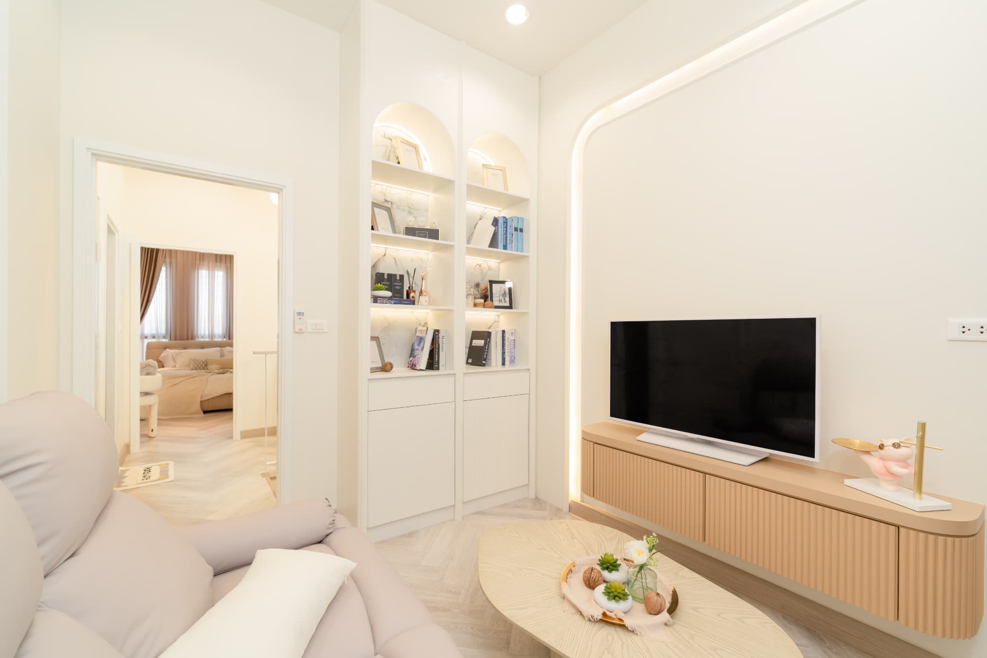 K Avenue II — soft cream living room with a sofa, media wall and built-in shelving
