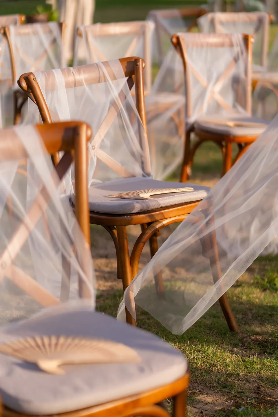 Wedding Setup — vertical view of the chair rows on the lawn in warm afternoon sunlight — ภาพงานแต่งงานและคู่บ่าวสาว