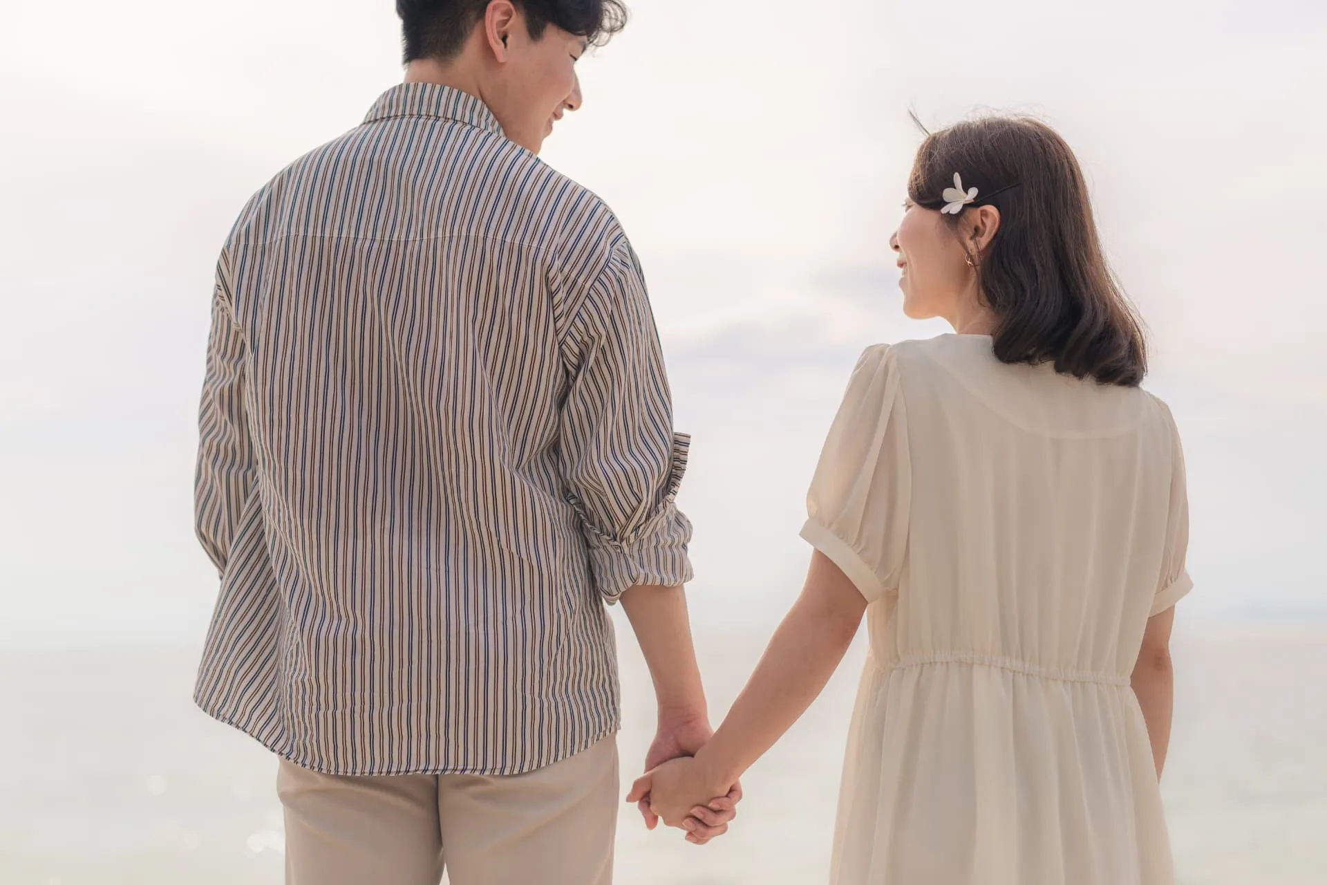 Couple holding hands and looking at each other by the sea — ภาพคู่รักและช่วงเวลาร่วมกัน