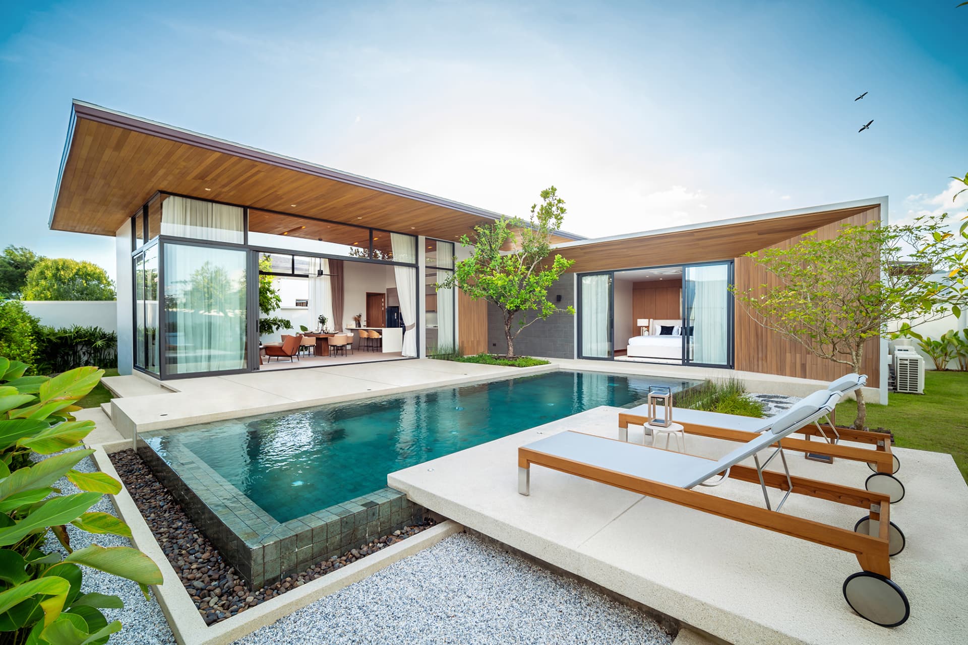 Botanica Four Seasons — modern pool villa exterior with a wide timber roof and planted garden