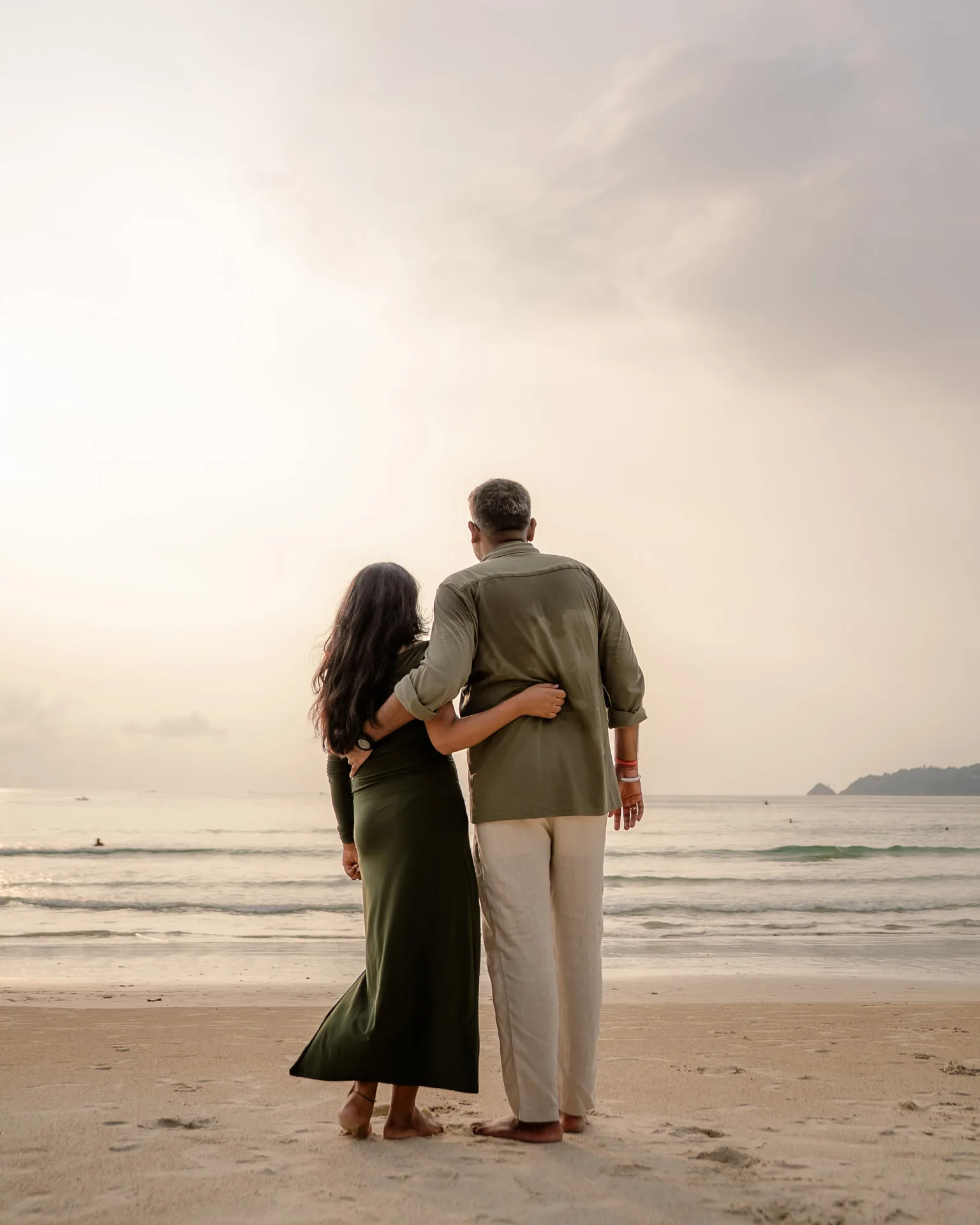 Couple walking arm in arm along the shoreline — ภาพคู่รักและช่วงเวลาร่วมกัน