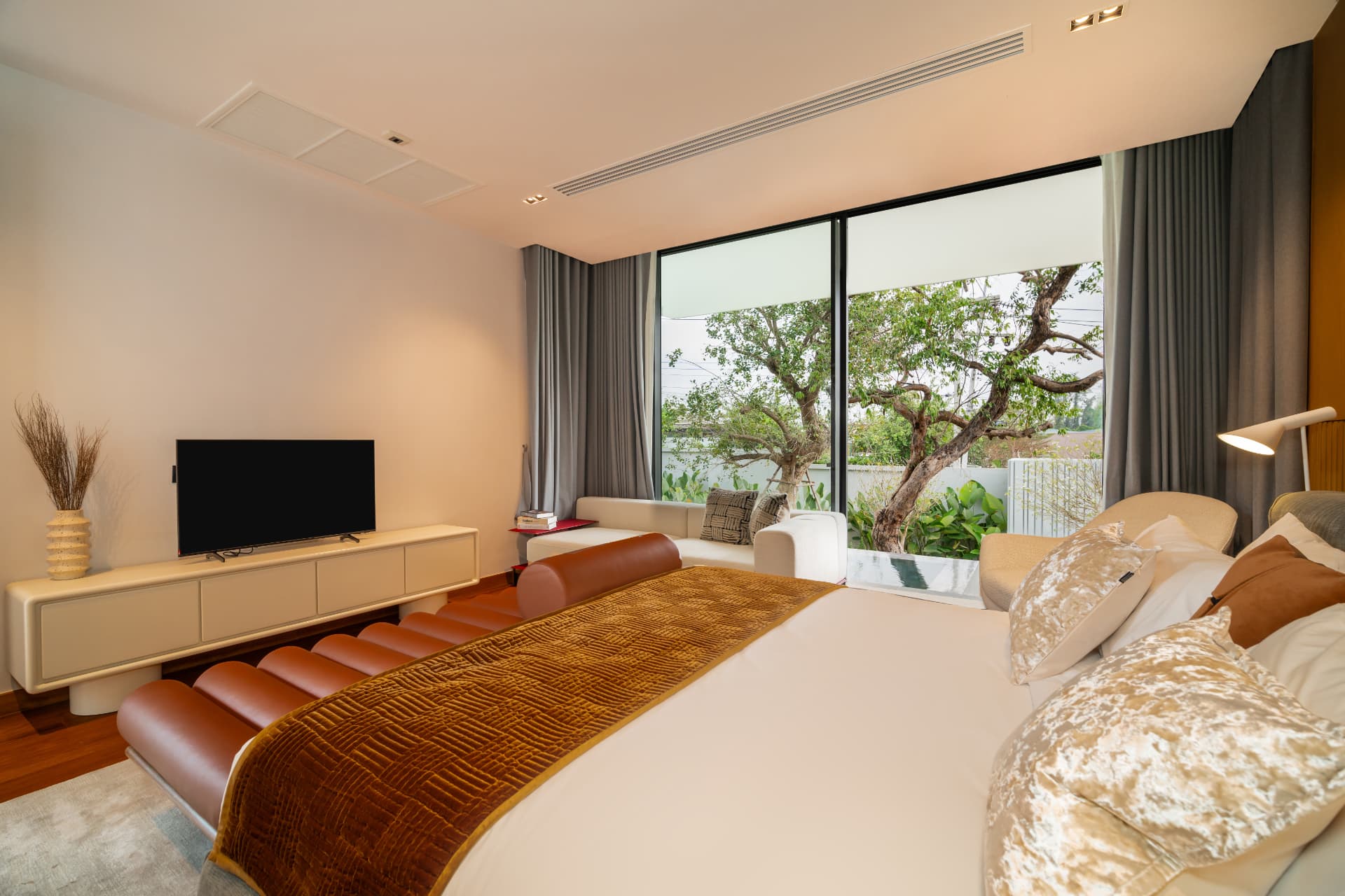 Botanica Foresta II — bedroom with a leather bench and garden view through full-height glazing