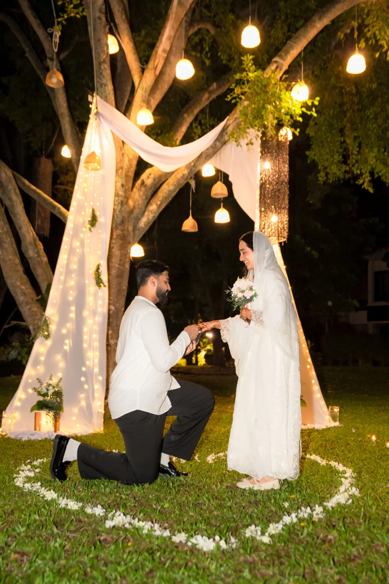 Marriage proposal beneath a decorated tree — ภาพช่วงเวลาขอแต่งงาน