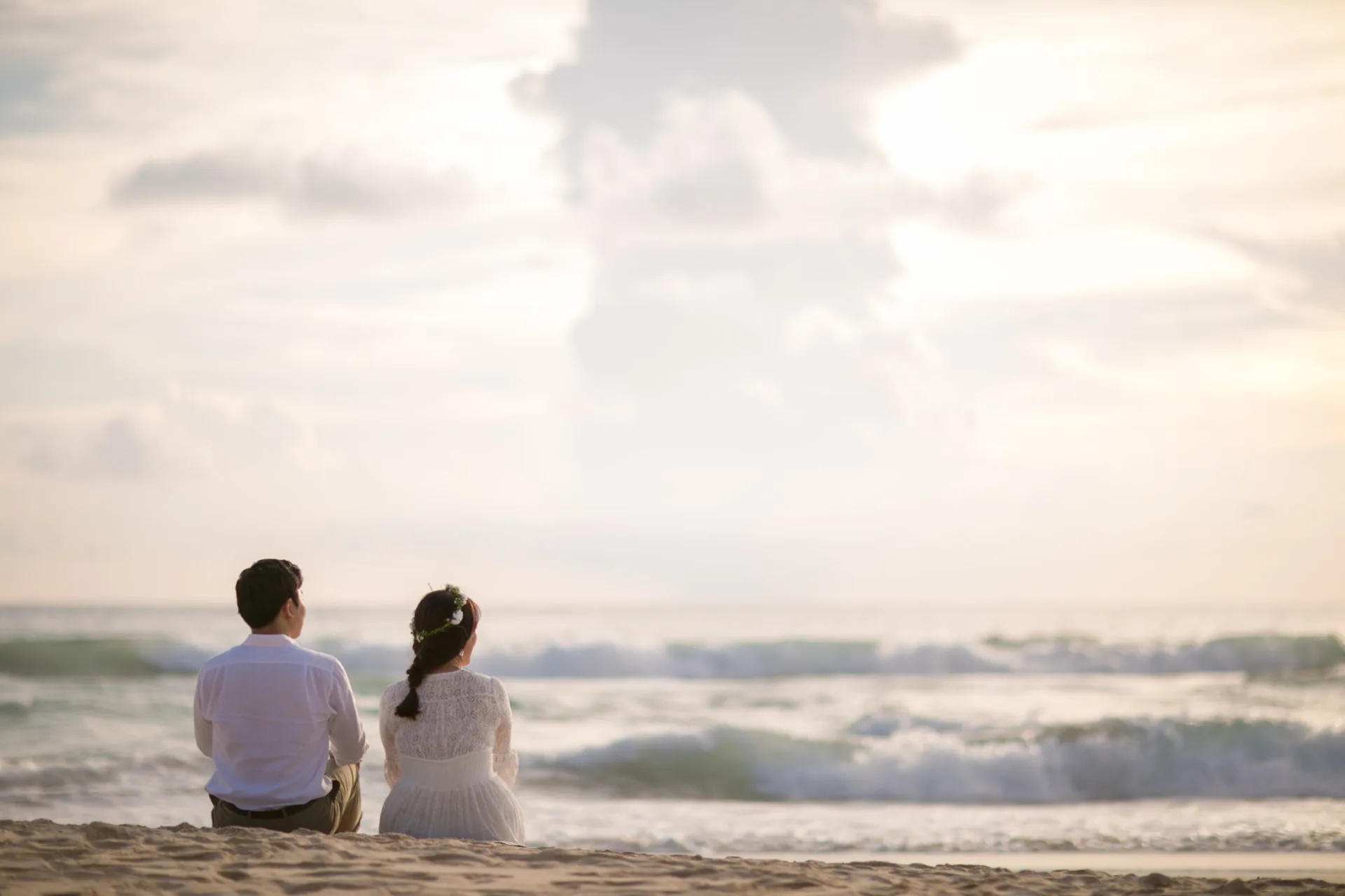 Couple sitting on the sand watching the waves — ภาพคู่รักและช่วงเวลาร่วมกัน