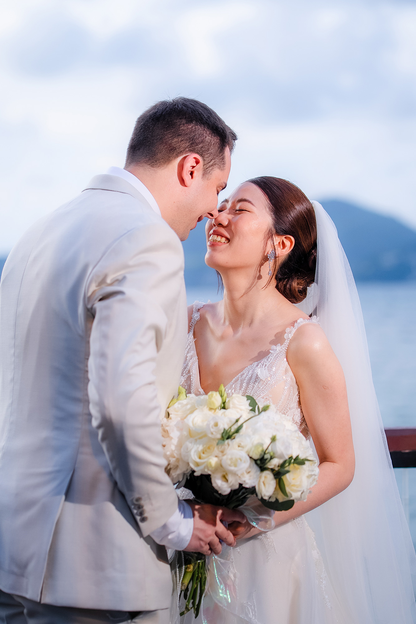 Thomas & Jane The Wedding — groom nuzzling the laughing bride's cheek as she holds a white bouquet