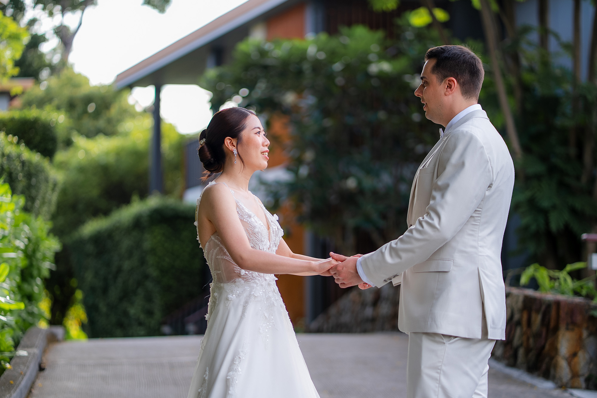 Thomas & Jane The Wedding — bride and groom holding hands during a first look on a garden path