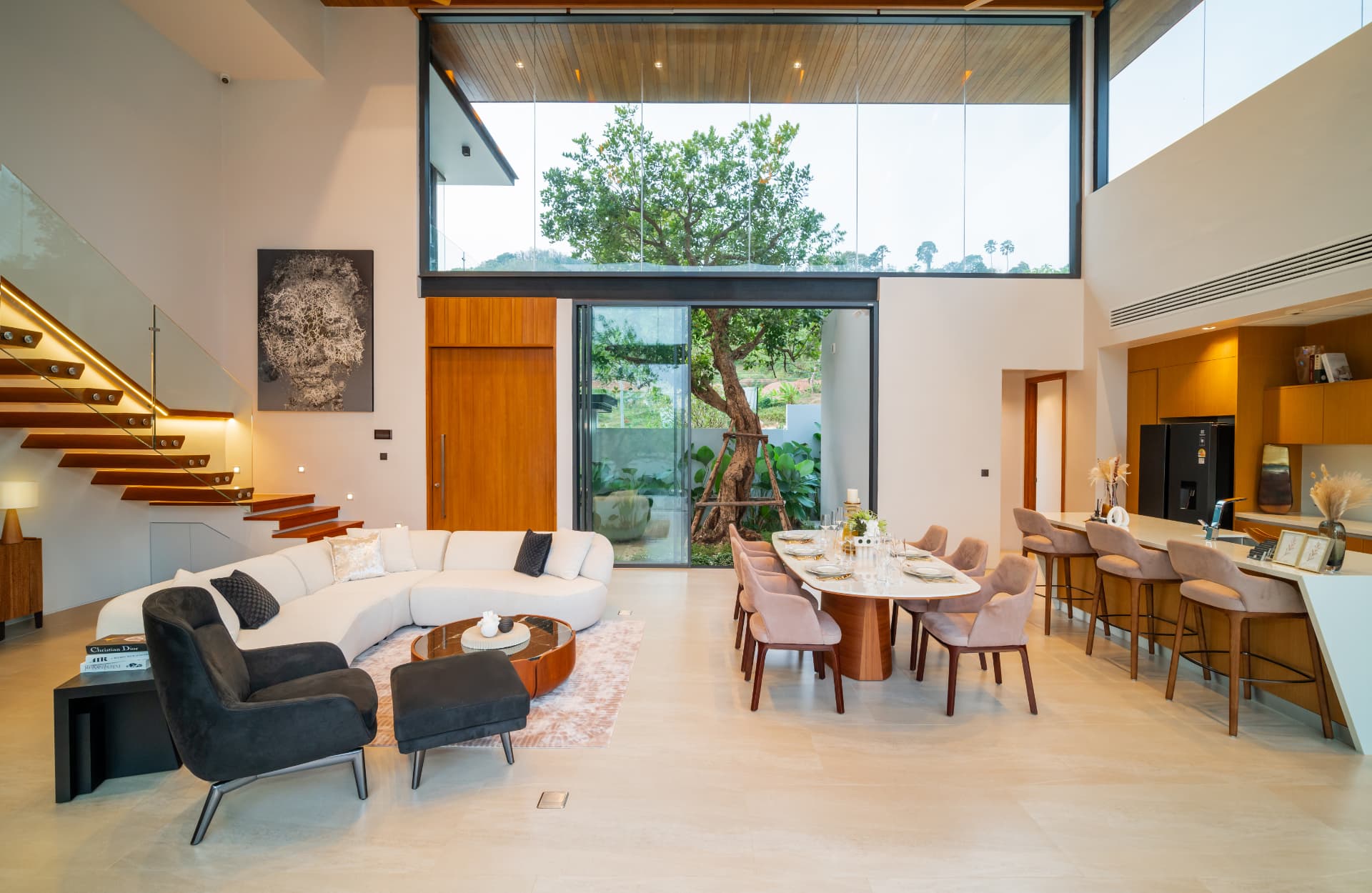Botanica Foresta II — double-height living and dining space opening to a planted courtyard