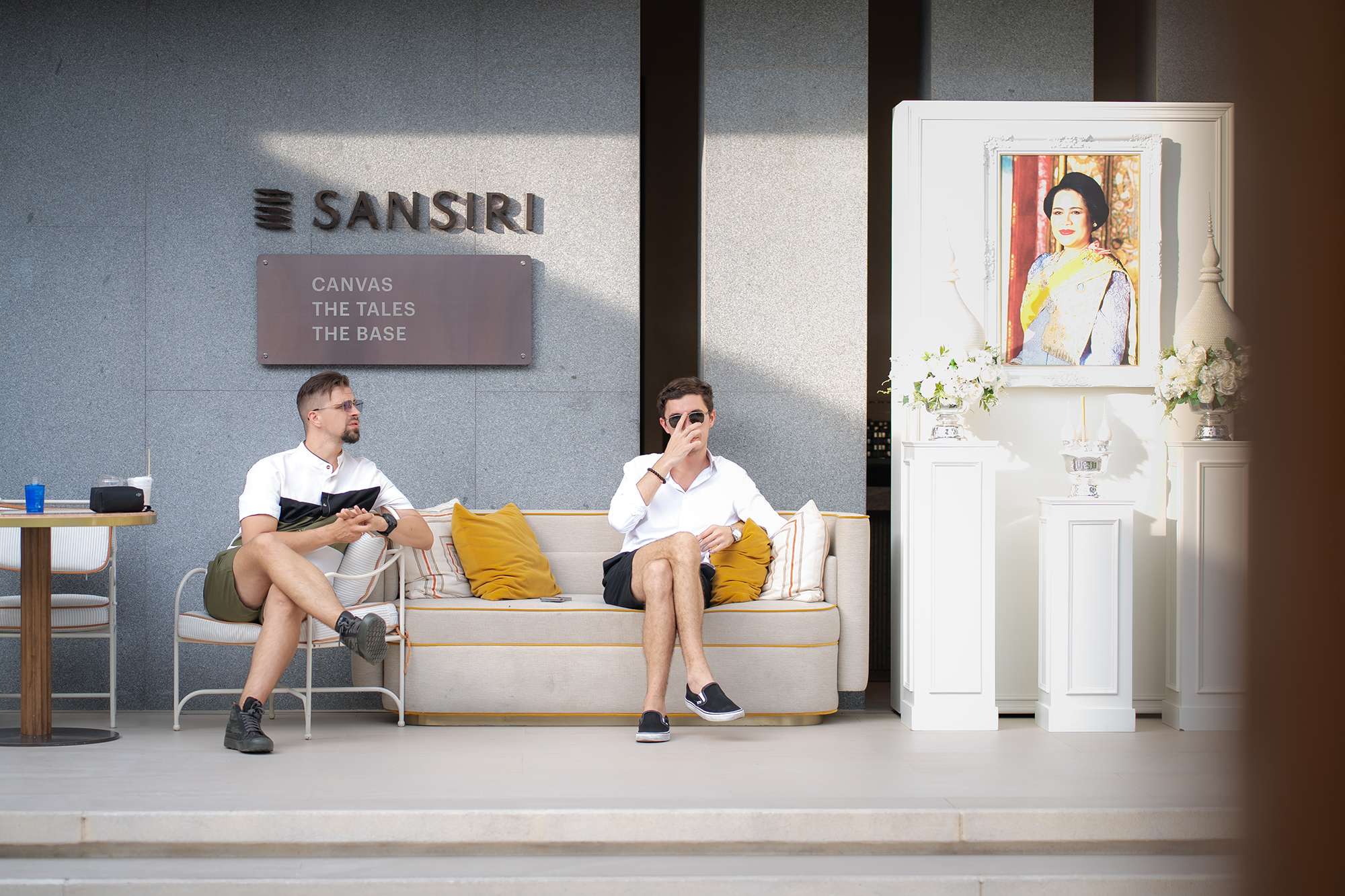 Sansiri New Year Dinner — two guests chatting on a cream sofa beneath the SANSIRI signage
