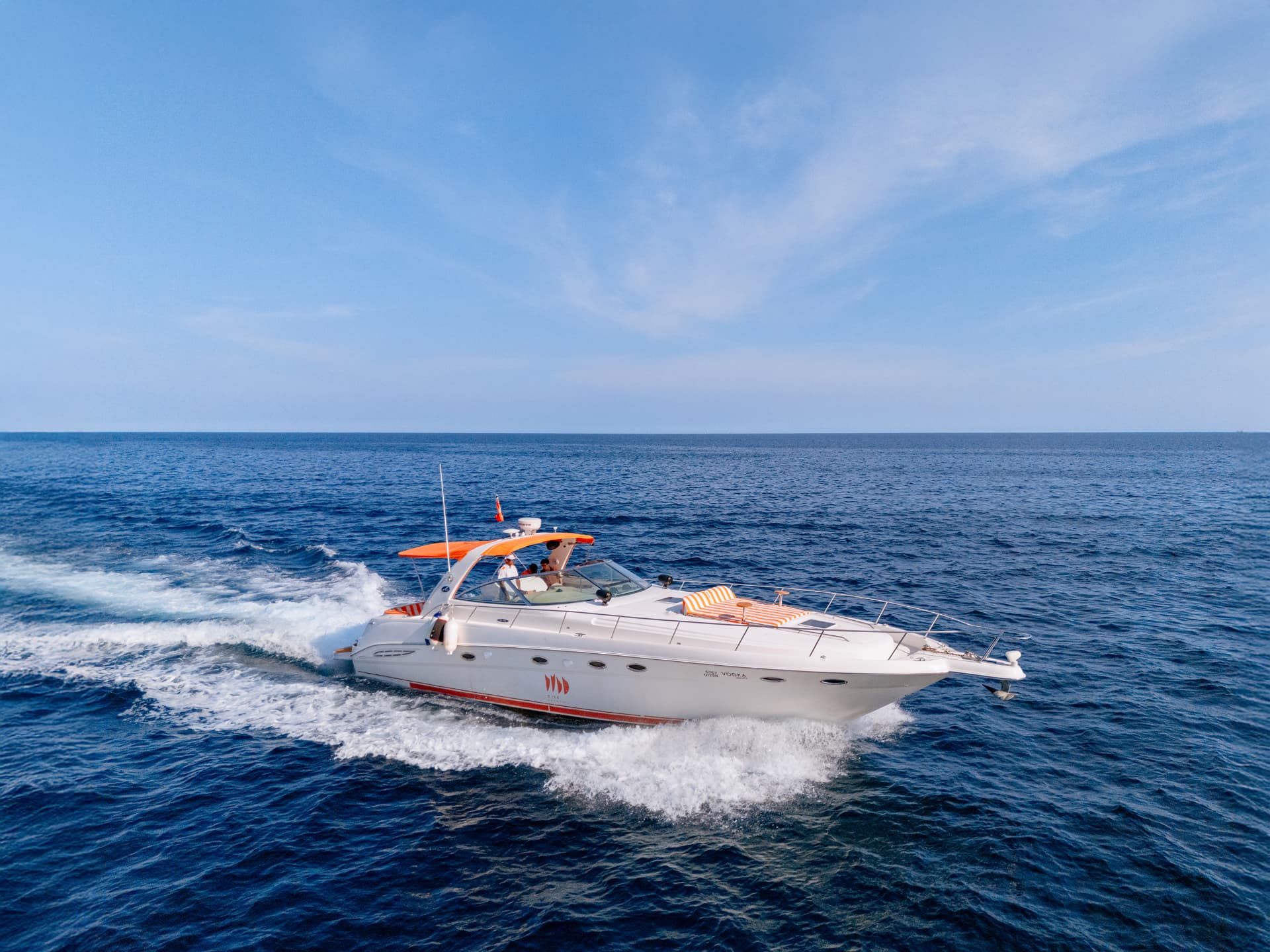 Once Yachting — the yacht cutting through the sea at speed with spray under a clear horizon