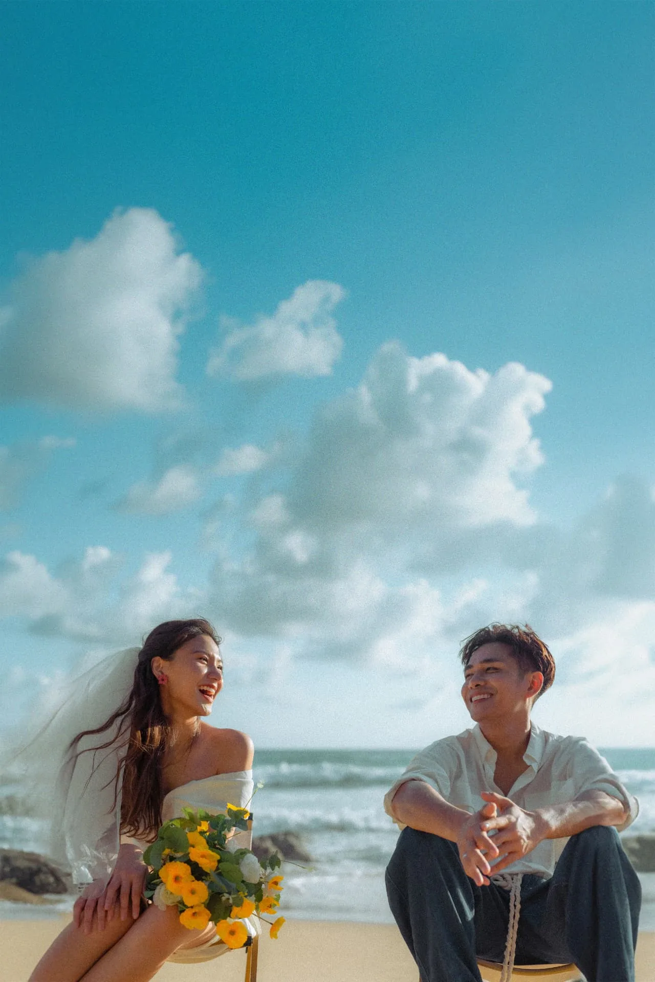 Couple sitting together on a sunny beach — ภาพคู่รักและช่วงเวลาร่วมกัน