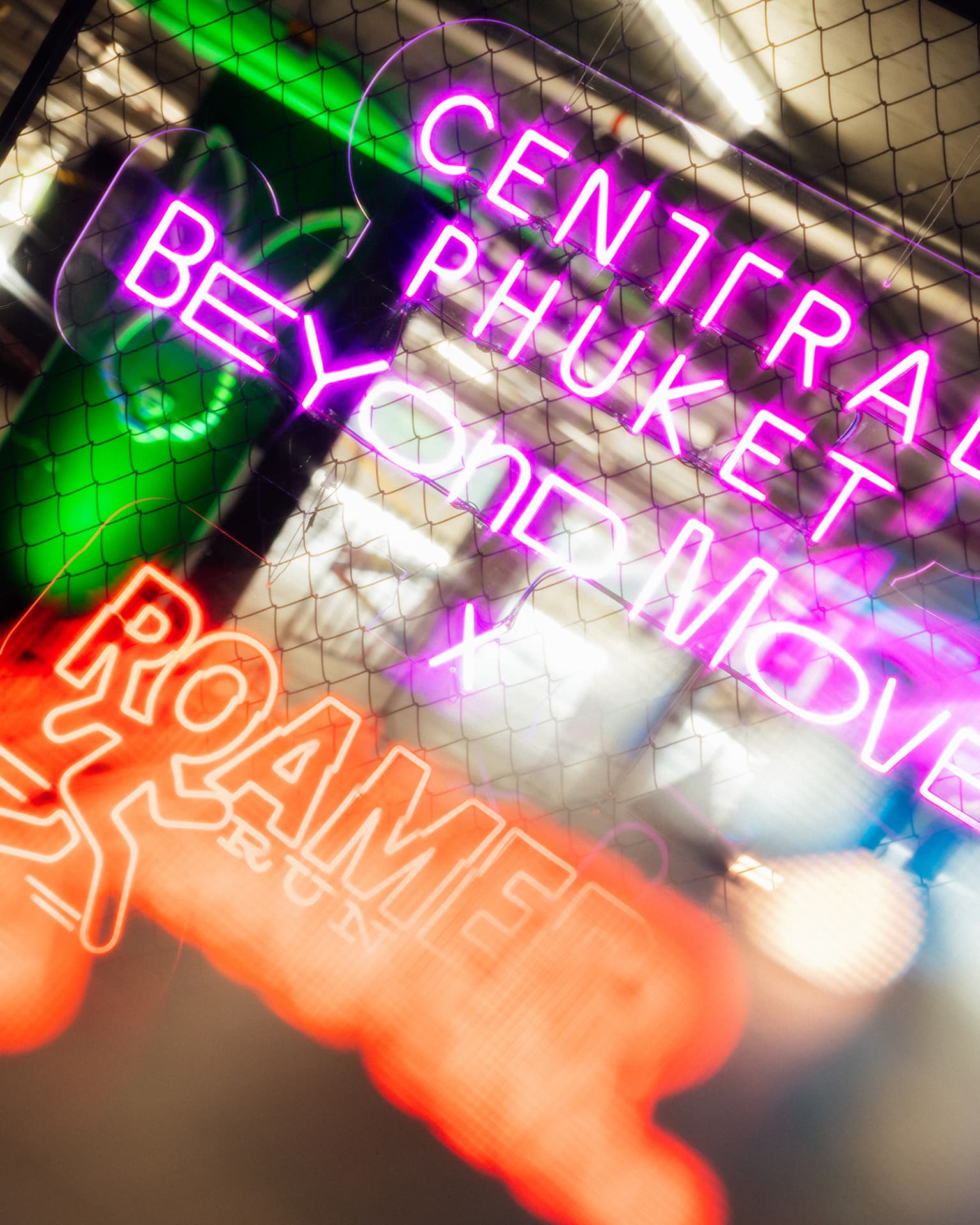 Central Phuket Beyond Move — glowing Beyond Move x Roamer neon sign on a chain-link fence