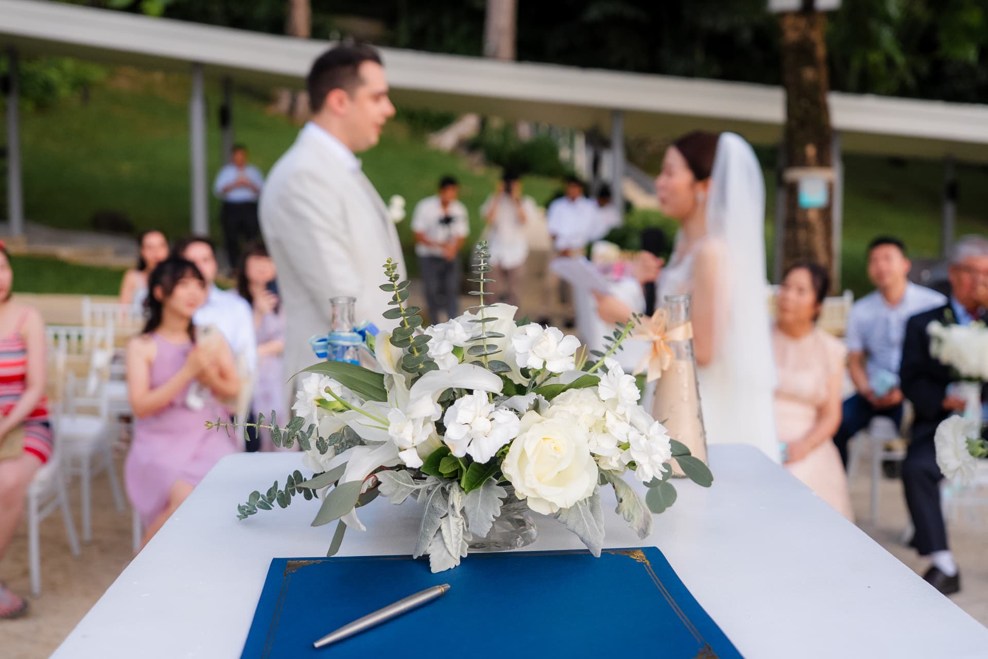 Thomas & Jane The Wedding — signing table dressed with white flowers while guests look on