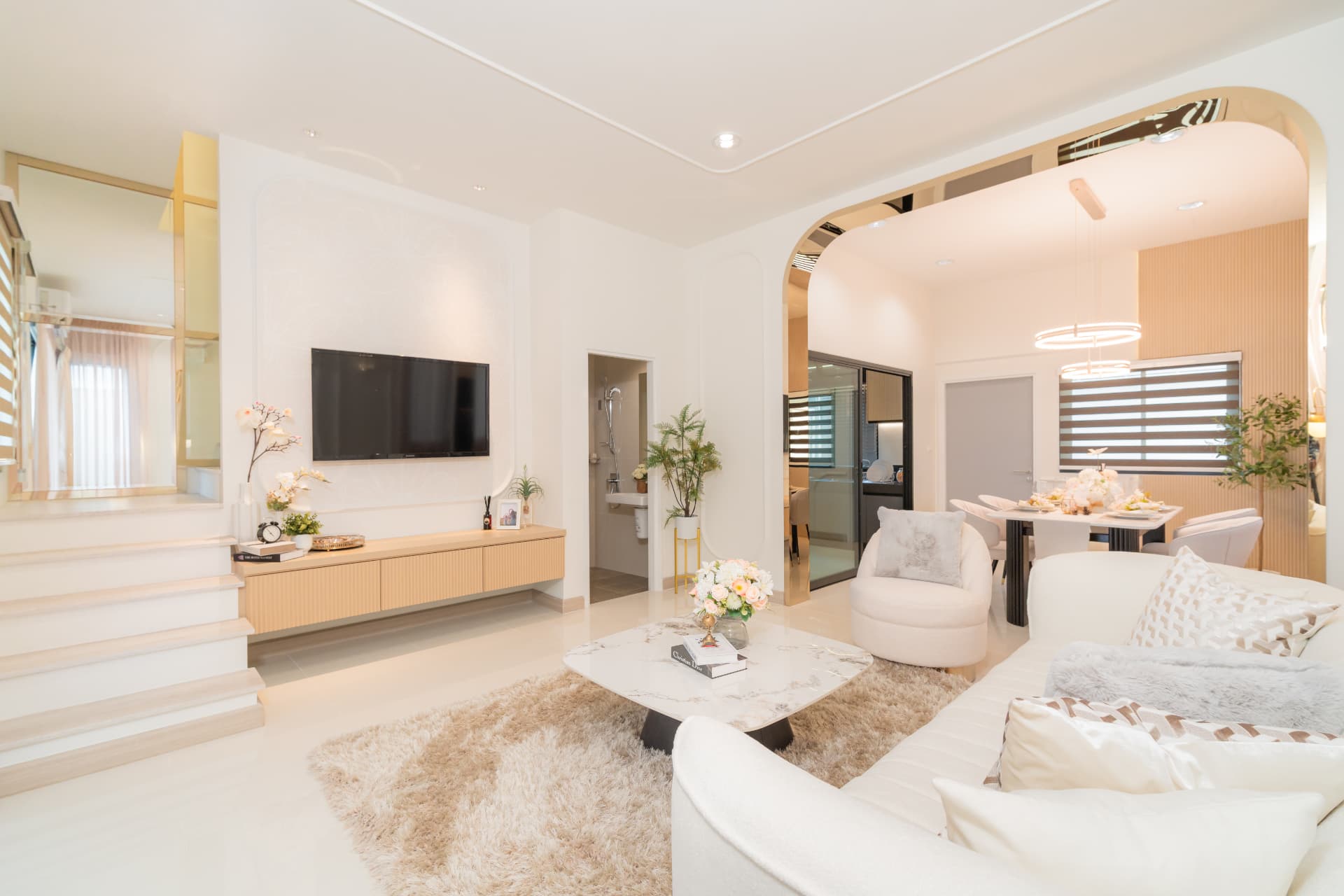 K Avenue II — living room with a marble media wall and curved archway