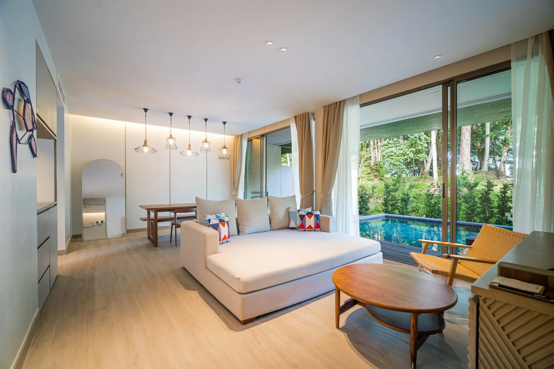AVANI+ KAO LAK — Living room with a sofa and timber lounge chairs