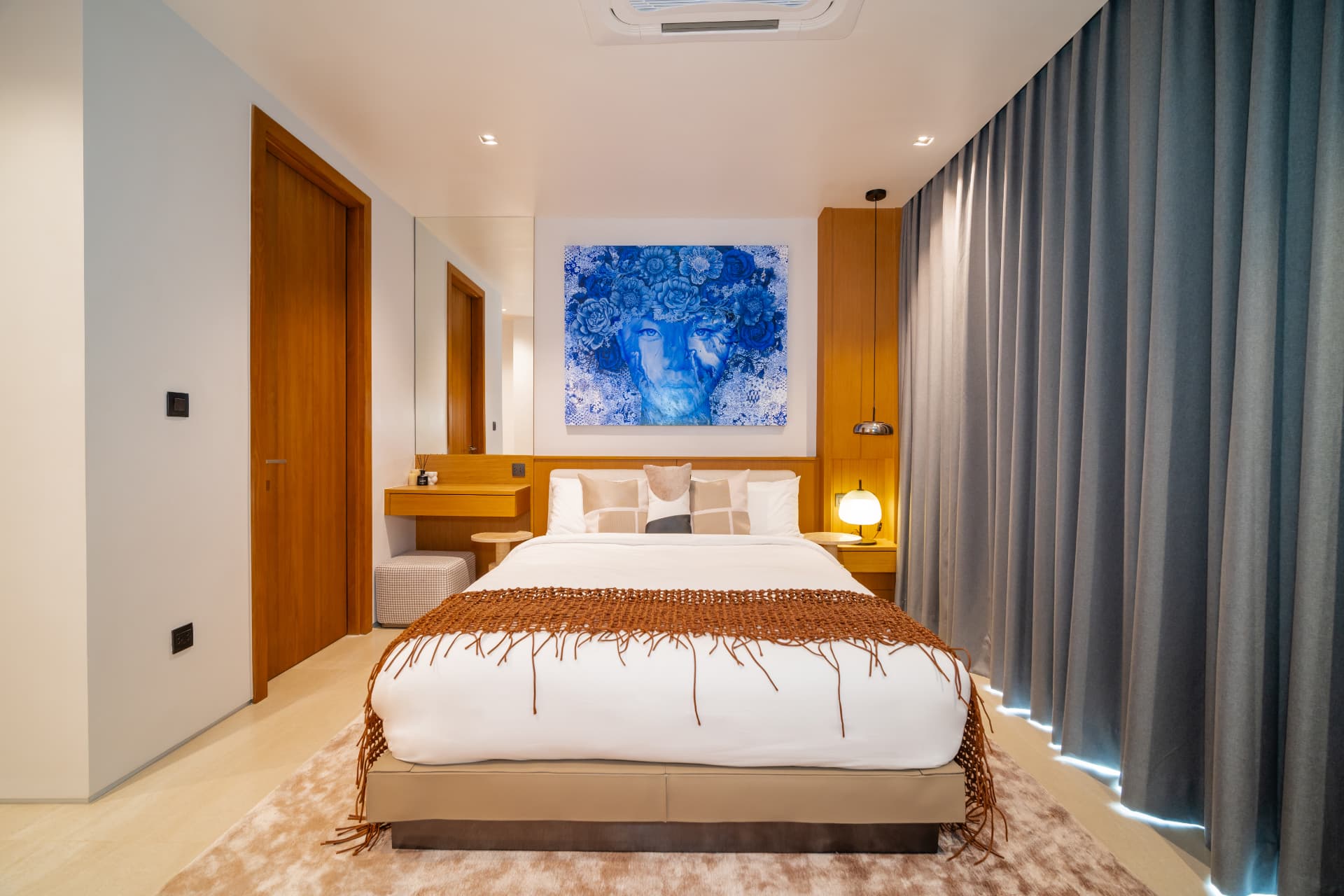Botanica Foresta II — bedroom with a dressed bed beneath a large blue floral painting